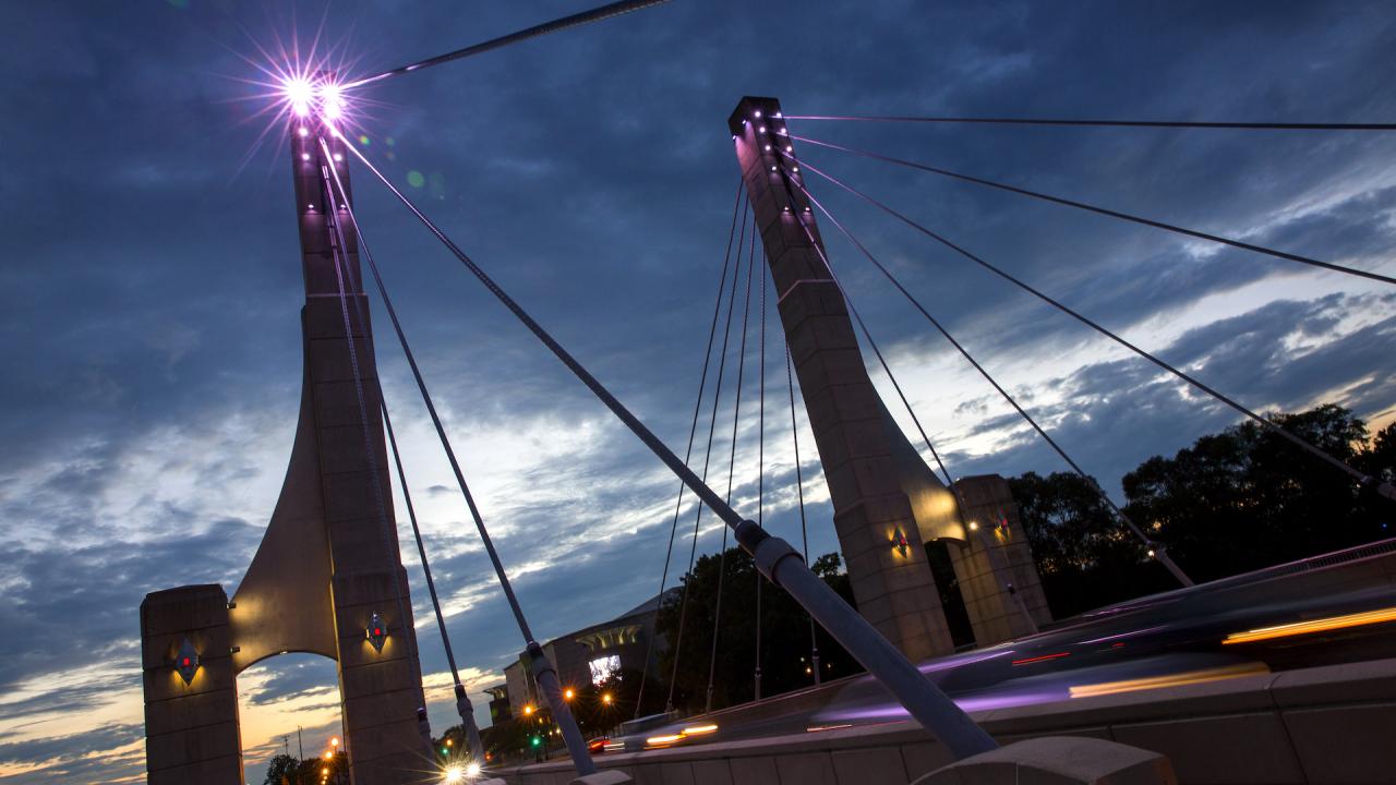 Photo of the Lane Ave. bridge at night, with Purple lights illuminating the bridge.